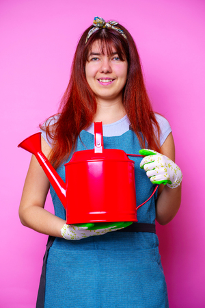 Photo of happy florist brunette woman with watering can in handの写真素材