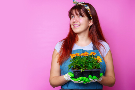 Photo of happy woman looking at side with marigolds in her handsの写真素材