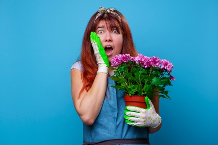 Image of surprised brunette woman with chrysanthemumsの写真素材