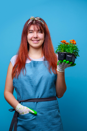 Photo of happy brunette girl with marigolds in her handsの写真素材
