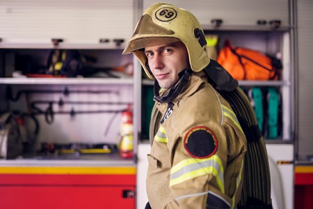 Picture of man fireman in helmet on background of fire truck
