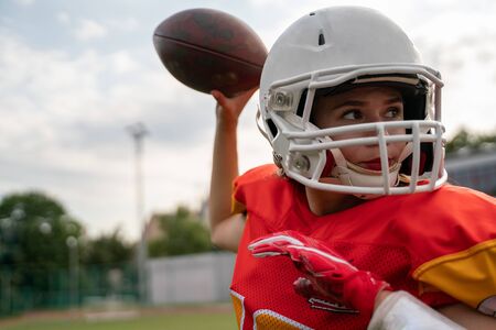 Photo of american football player woman throwing ballの写真素材