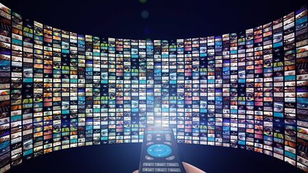 Image of big screen with many multi-colored channels, hands of man with remote control.の写真素材