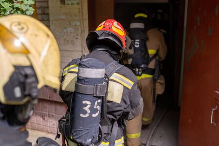 Group of firefighters in helmets entering buildingの写真素材