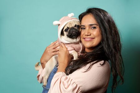 Woman with pug on blank blue backgroundの写真素材