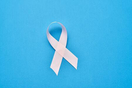 Realistic white ribbon isolated on blue backgroundの写真素材