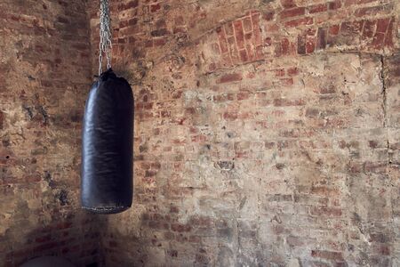 Gym in loft style, close-up of punching bag for boxing