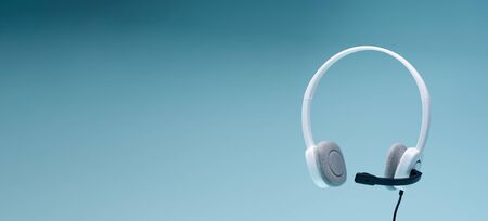 Headphones on blank blue background, place for text. Call centerの写真素材
