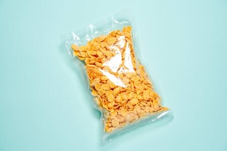 corn flakes sealed in plastic bag on blue background