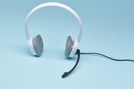 Headphones with black microphone isolated on blank blue background, close-upの写真素材