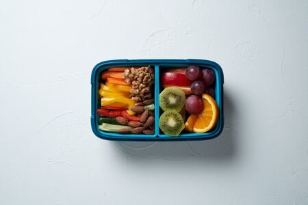Top View of Full Lunch Box with Fuits, Vegetables and nuts.