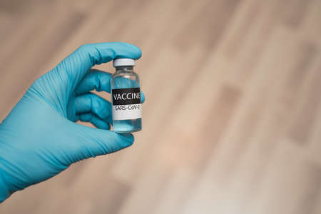 Hand in protective gloves holding vaccine.の写真素材