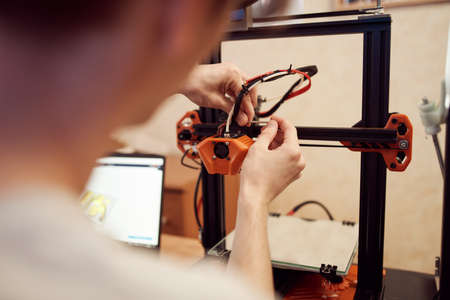 Young man set up 3d printer