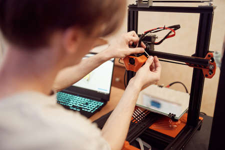 Young man set up 3d printerの写真素材