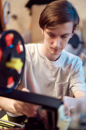 Young man set up 3d printerの写真素材