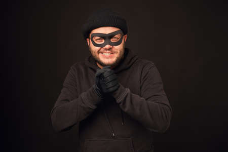 Portrait of funnu thief with mask over dark backの写真素材