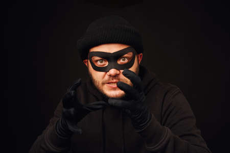 Portrait of funnu thief with mask over dark backの写真素材
