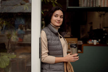 Young female taking coffee break in cafeteria