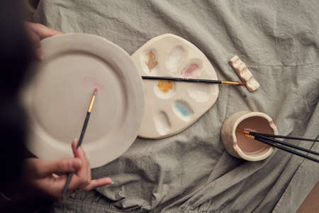 Crop woman painting on plateの写真素材