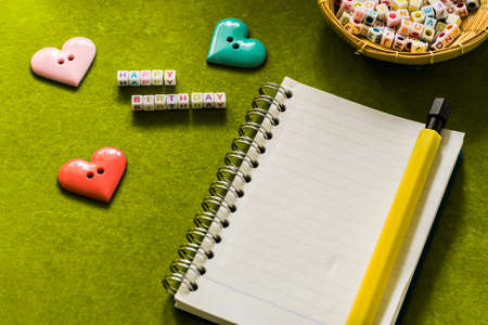 Happy birthday and notepad with pen.の写真素材
