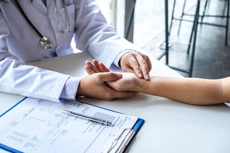 Doctor checking measuring pressure on patient's hand pulse by hands, Medical and healthcare concept.の写真素材