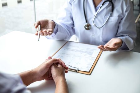 Doctor and patient are discussing consultation about symptom problem diagnosis of disease talk to the patient about medication and treatment method.の写真素材