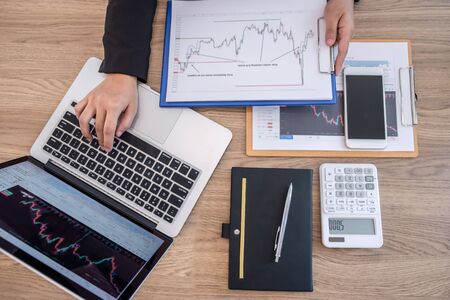 Businesswoman working and planning in investment trading marketing project and using calculator to analyzing data graph of deal a stock exchange to financial business profit.の写真素材