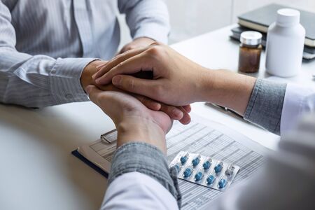 Hand of doctor touching patient reassuring for encouragement and empathy to support while medical examination on the hospital.の写真素材