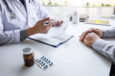 Doctor presenting with patient and checking results on report and prescription about the problem of illness and recommend using medicine, healthcare and medical concept.の写真素材