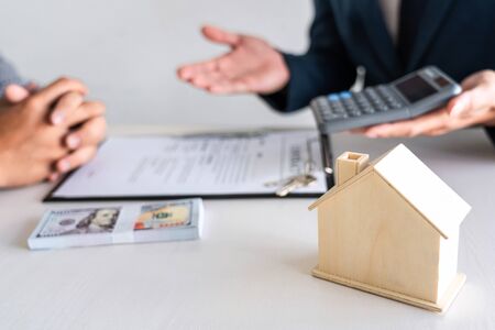 Sale purchase contract to buy a house, Real estate agent are presenting home loan and giving keys to customer after signing contract to buy house with approved property application form.の写真素材