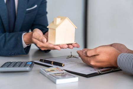 Real estate agent are presenting home loan and giving house to customer after signing contract to buy house with approved property application form.の写真素材