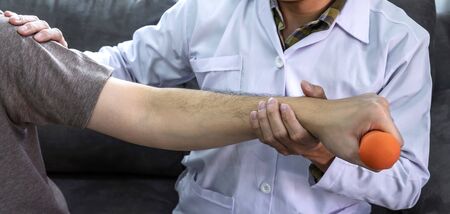 Doctor physiotherapist treating rehabilitation arm pain patient doing physical therapy exercises...
