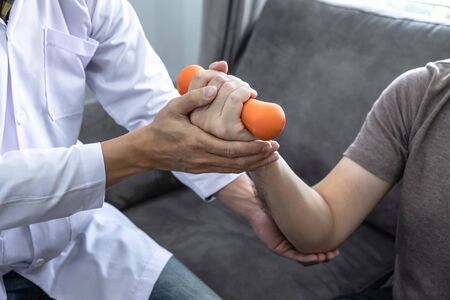 Doctor physiotherapist treating arm pain patient doing physical therapy exercises with his therapist...