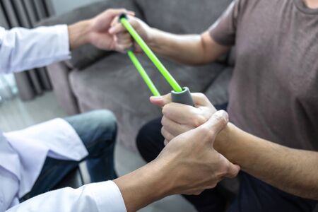 Doctor physiotherapist treating arm pain patient doing physical therapy exercises with his therapist...