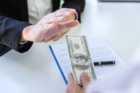 Businessman refusing receive bribe money in the envelope of their partner to give success the deal...