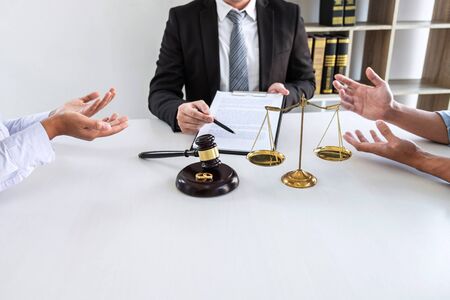 Young angry couple arguing telling their problems in the courthouse to getting divorced or premarital agreement in lawyers office, deciding on marriage divorce concept.の写真素材