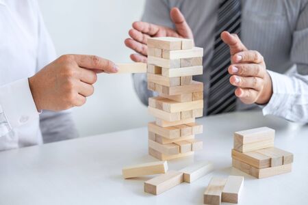 Planning Risk and Strategy in Business, Image of two Businessman hand placing making wooden block structure growing up the tower and protection to planning and development to successful.の写真素材