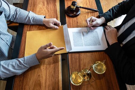 Professional male lawyer or counselor discussing negotiation legal case with client meeting with document contract in office, law and justice, attorney, lawsuit concept.