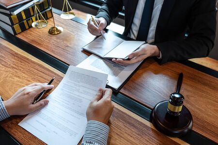 Male lawyer discussing negotiation legal case with client meeting with document contact in courtroom, law and justice concept.の写真素材