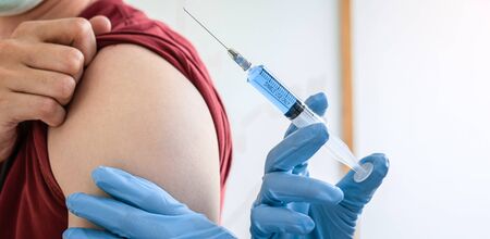 Doctor making a vaccination into patient with needle getting immune vaccine at arm for flu shot, coronavirus protective of epidemic.の写真素材