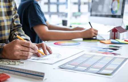 Team design of young Interior graphic designer working house project sketching on graphic tablet and...