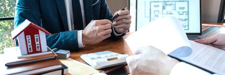 Real estate agent are presenting home loan and sending keys to customer after signing contract to...