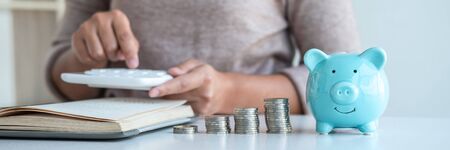 Young woman and piggy bank to planning growing saving strategy with pile coins for future plan fund of travel, education, home and retirement.の写真素材