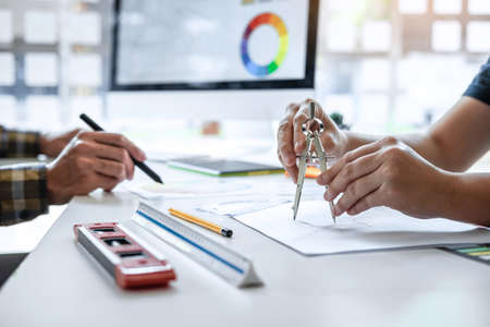 Team of young Interior graphic designer working sketching on graphic tablet and color swatch, discussing of house project at modern office, creative work place inspiration and imagine.の写真素材