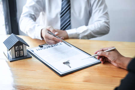 Estate agent are presenting home loan and giving house to client after discussing and signing agreement contract with approved application form, Home Insurance and Real estate investment concept.の写真素材