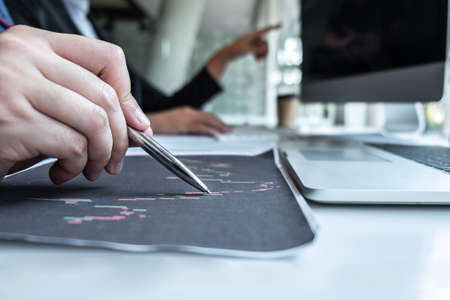 Business team investor working discussion in traders and pointing on the stock chart data presented...