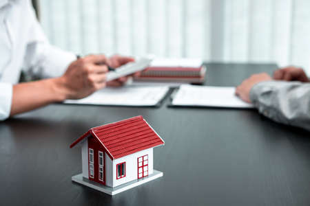 Estate agent are presenting home loan to client and discussing to decision signing agreement contract form, Home Insurance and Real estate investment concept.の写真素材