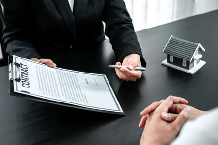 Estate agent are presenting home loan to client and discussing to decision signing agreement...