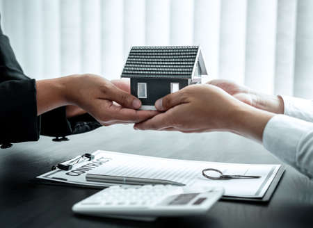 Sale Estate agent giving house model to new client after signing agreement contract with approved...