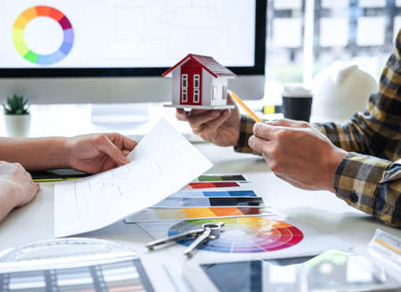 Team of young Interior graphic designer working sketching on graphic tablet and color swatch,...